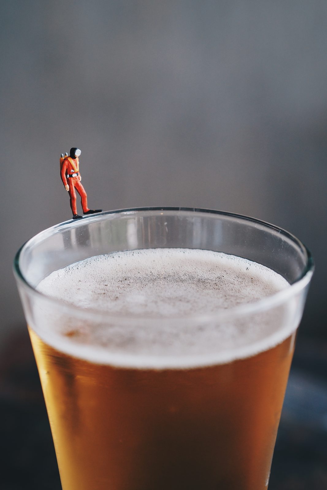 Miniatuurfiguur op de rand van een bierglas