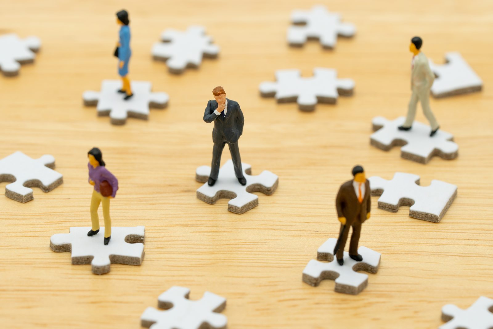 Miniatuurfiguren op puzzelstukken