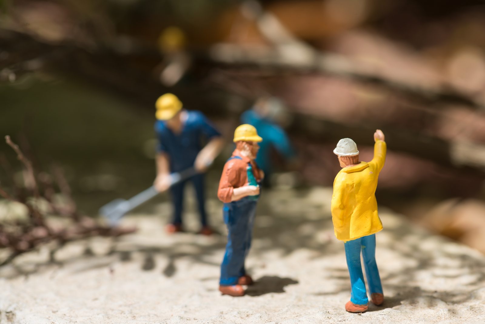 Miniatuur-arbeiders met helm aan het werk