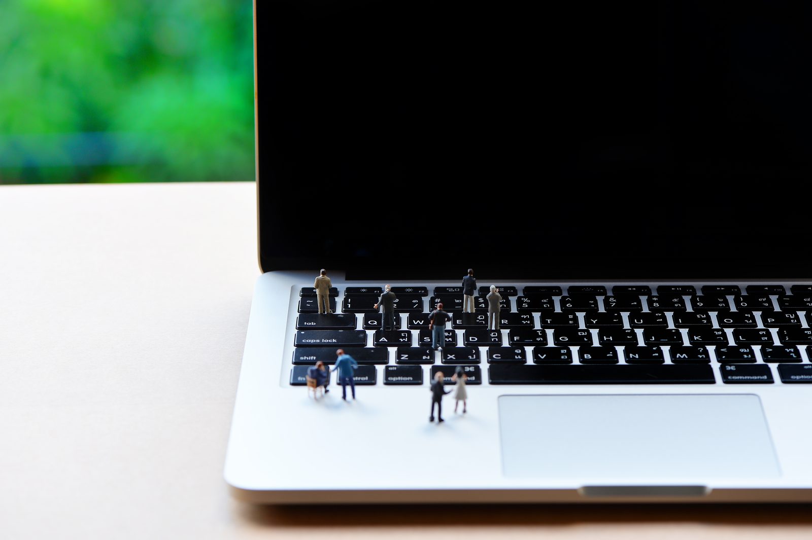 Miniatuurfiguren aan het werk op een laptop